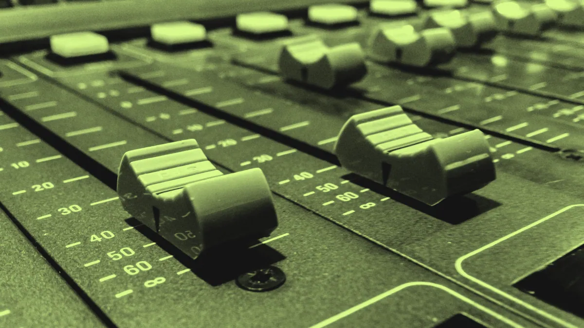 Channel faders on a mixing desk.