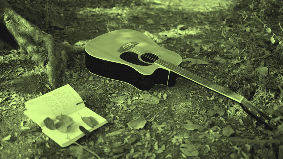 A guitar and a notebook, the tools of songwriting.